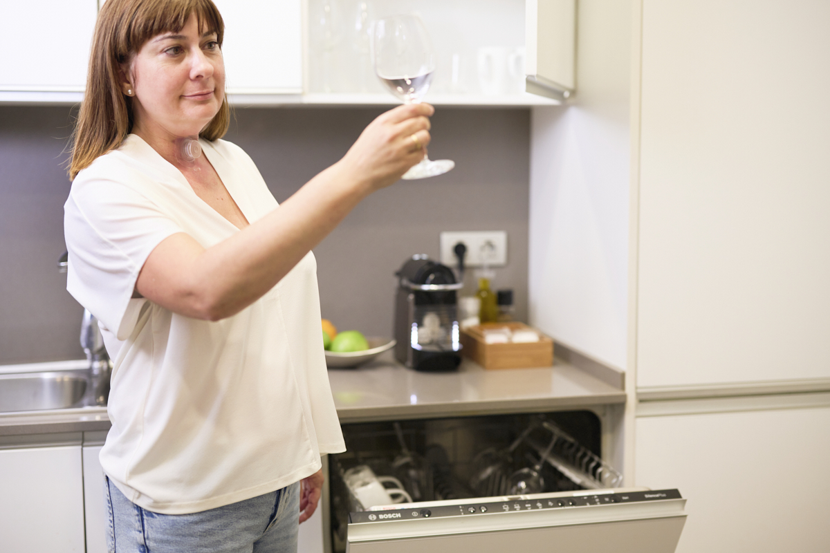 Woman with stoma doing washing living with laryngectomy